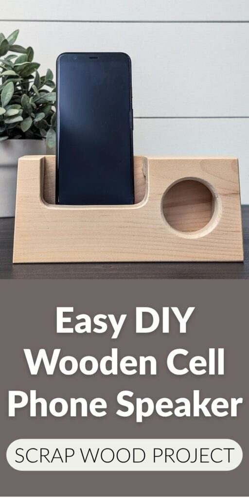 Wooden phone amplifier holding a smartphone in a curved slot with a round speaker opening on a tabletop next to a plant. Text overlay reads: “Easy DIY Wooden Phone Speaker Stand. Scrap Wood Idea.”
