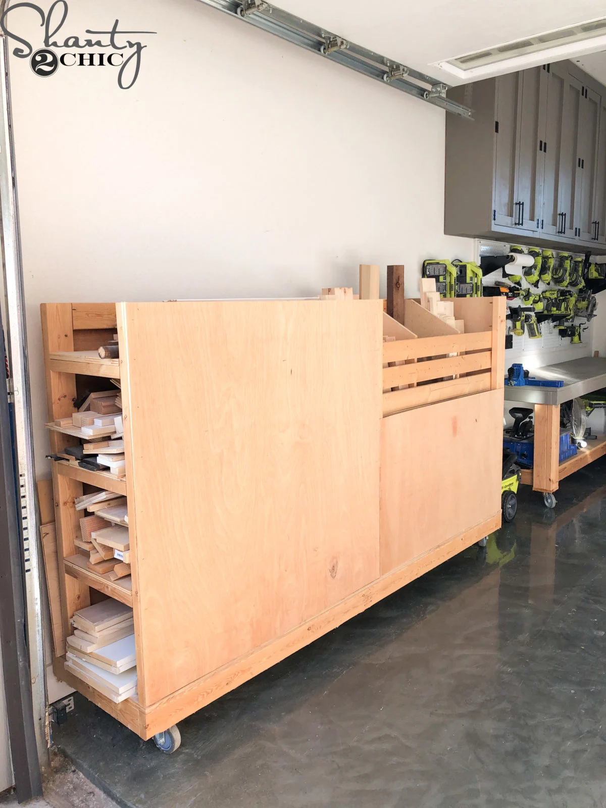 Large rolling DIY lumber cart with vertical plywood and board storage in a garage workshop.