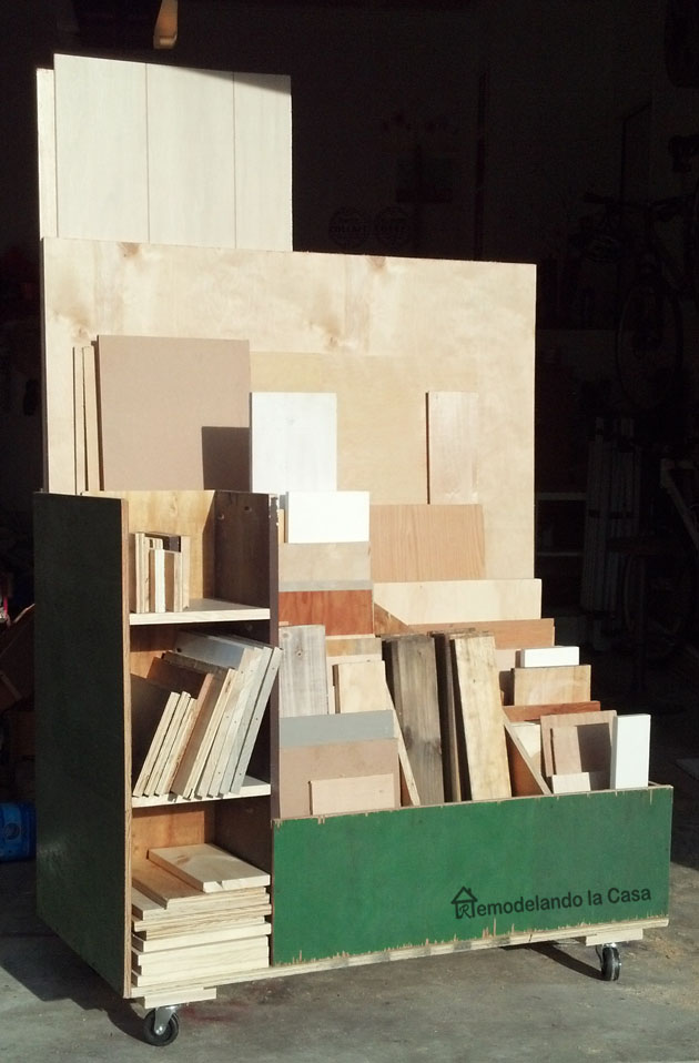 DIY rolling scrap wood cart with vertical storage compartments organizing plywood sheets, and small wood scraps in a garage workshop.