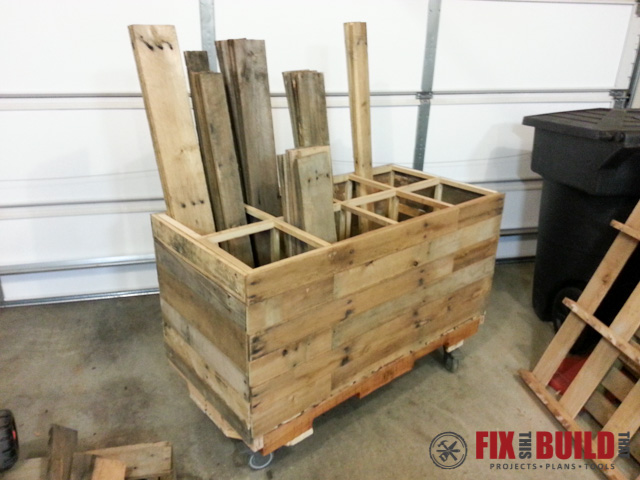 DIY rolling scrap wood cart made from reclaimed pallet wood with divided compartments for organizing lumber offcuts and wood scraps in a garage workshop.
