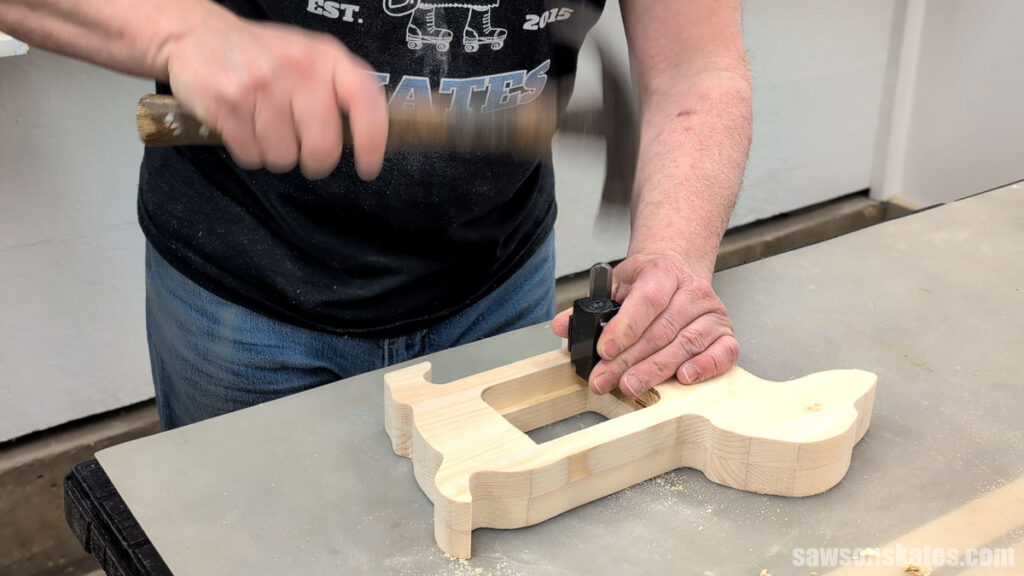 Person using a corner chisel and hammer to square an inside corner.