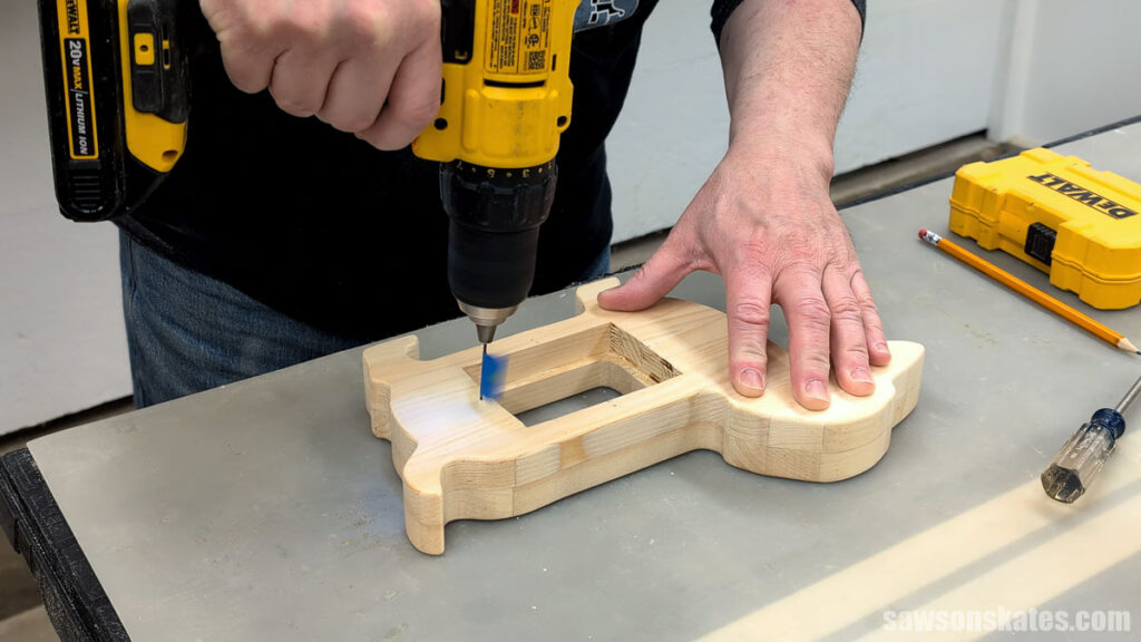 Person using a drill to make a pilot hole.