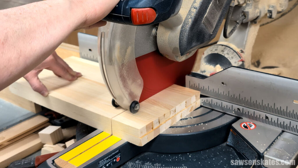 Trimming a board to length with a miter saw.