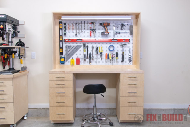 Garage workbench with storage drawers on either side and a pegboard above