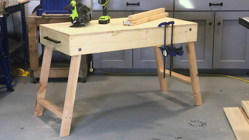 Folding workbench with tools on a concrete floor in a workshop