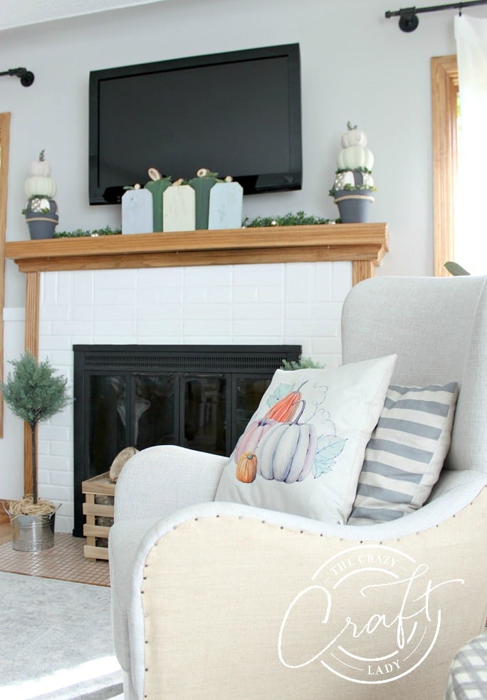 In the distance, five wood blocks on a mantel painted to look like pumpkins