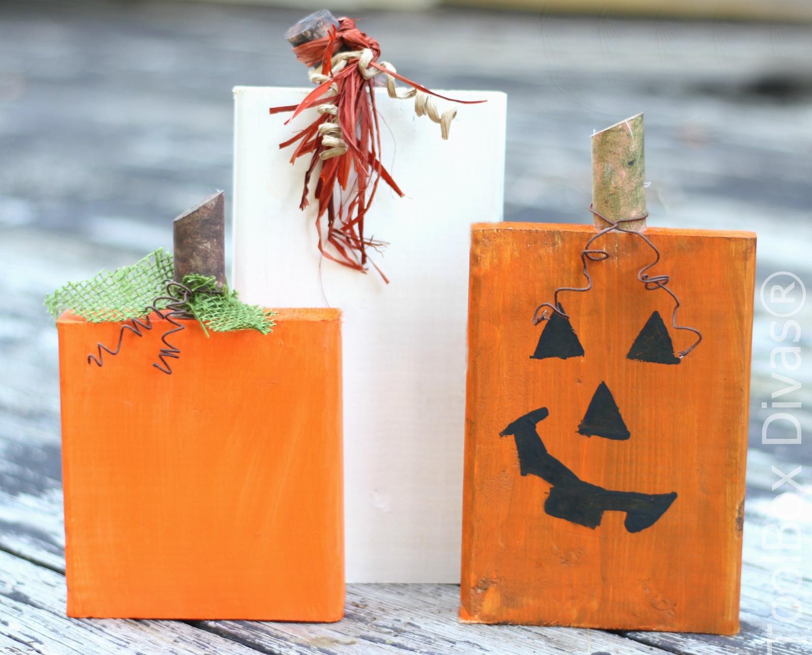 Three wood blocks painted to look like pumpkins and a jack-o-lantern