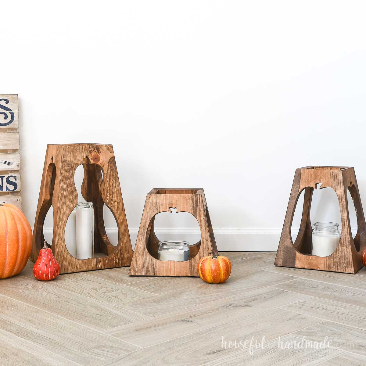 Three wood lanterns with pumpkin cutouts