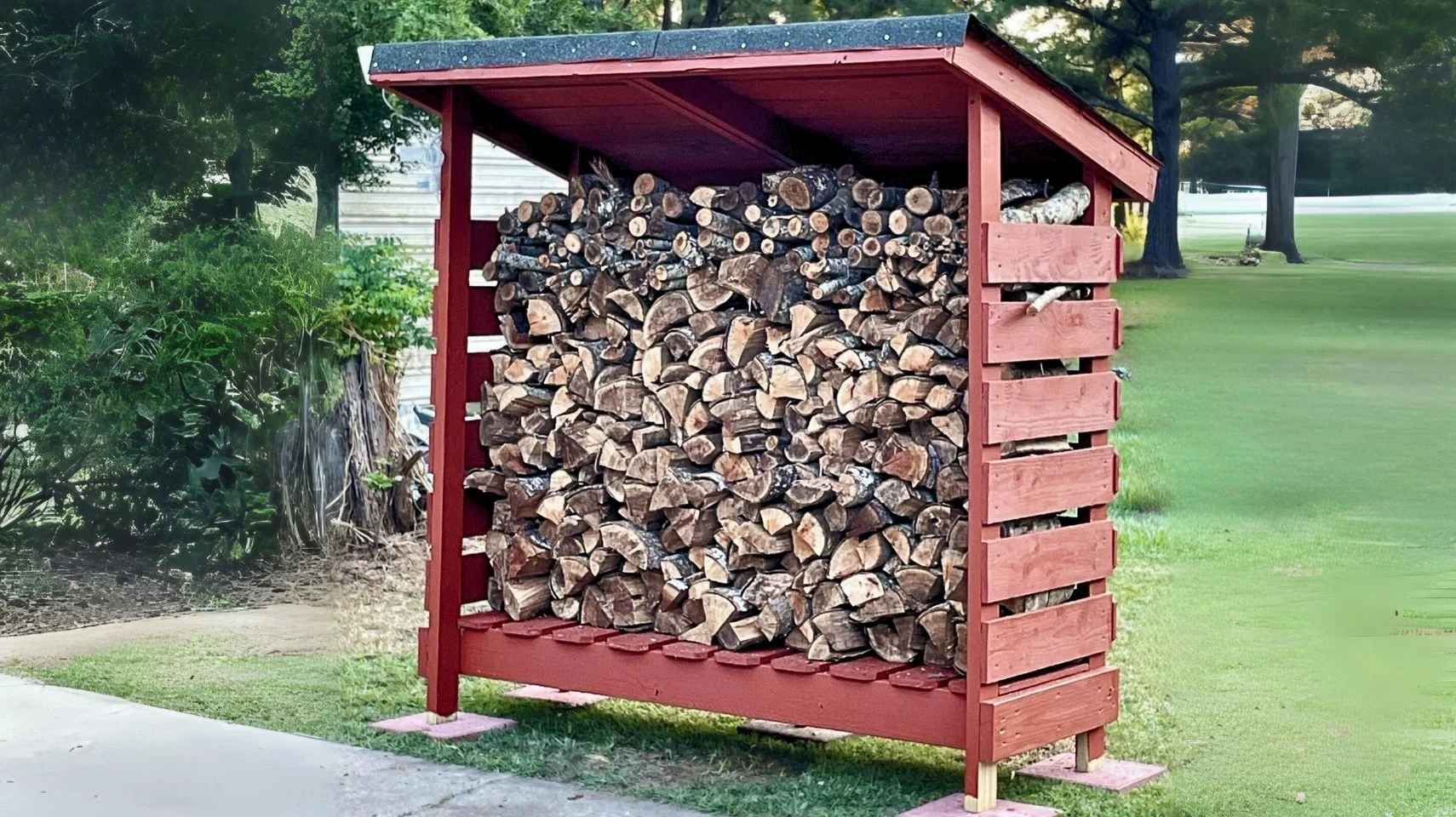 Red-painted firewood shed in a yard