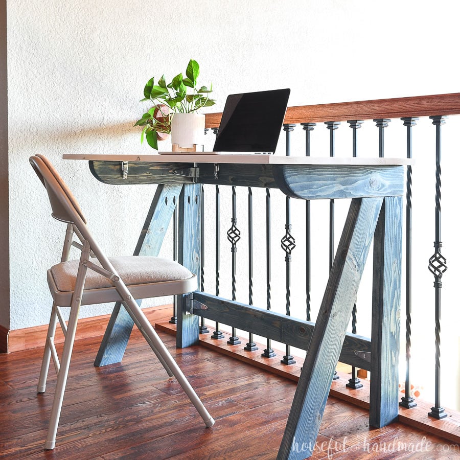 Desk with slanted legs and a laptop and a plant