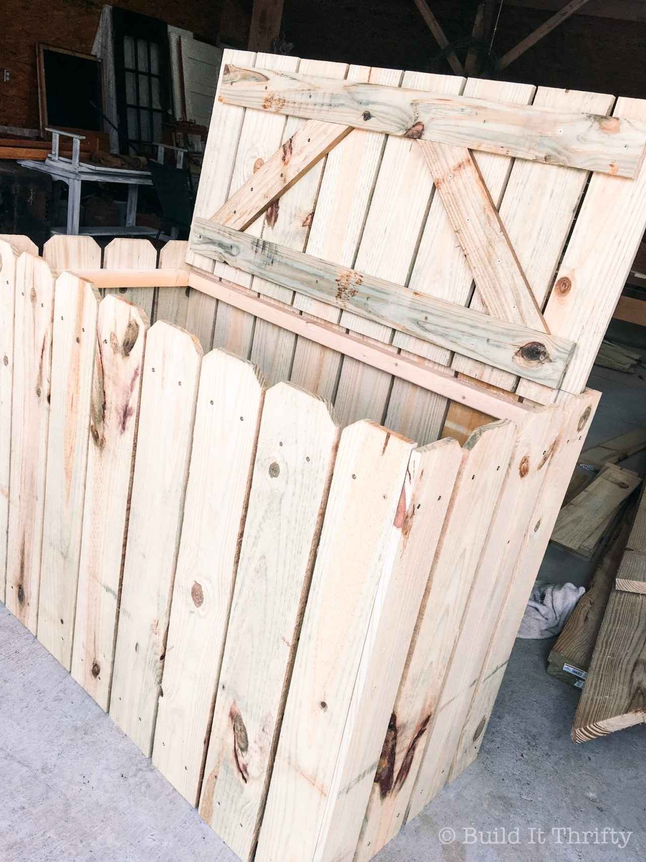 Cedar enclosure with the lid open for storing garbage cans