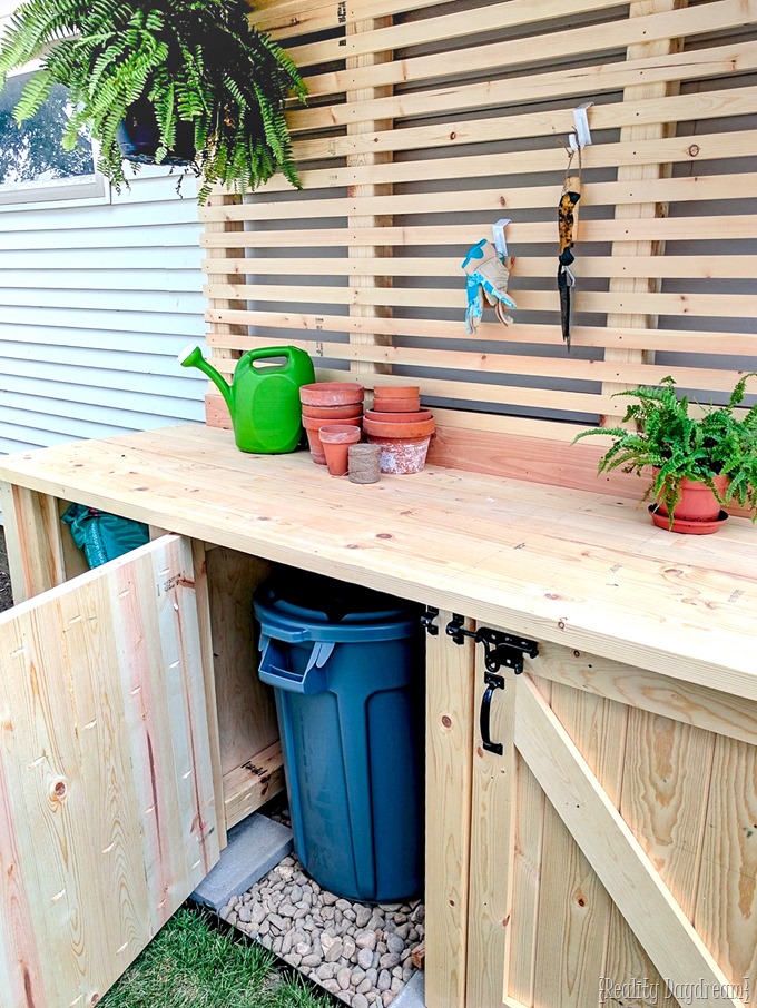Wooden potting bench with garbage can storage below