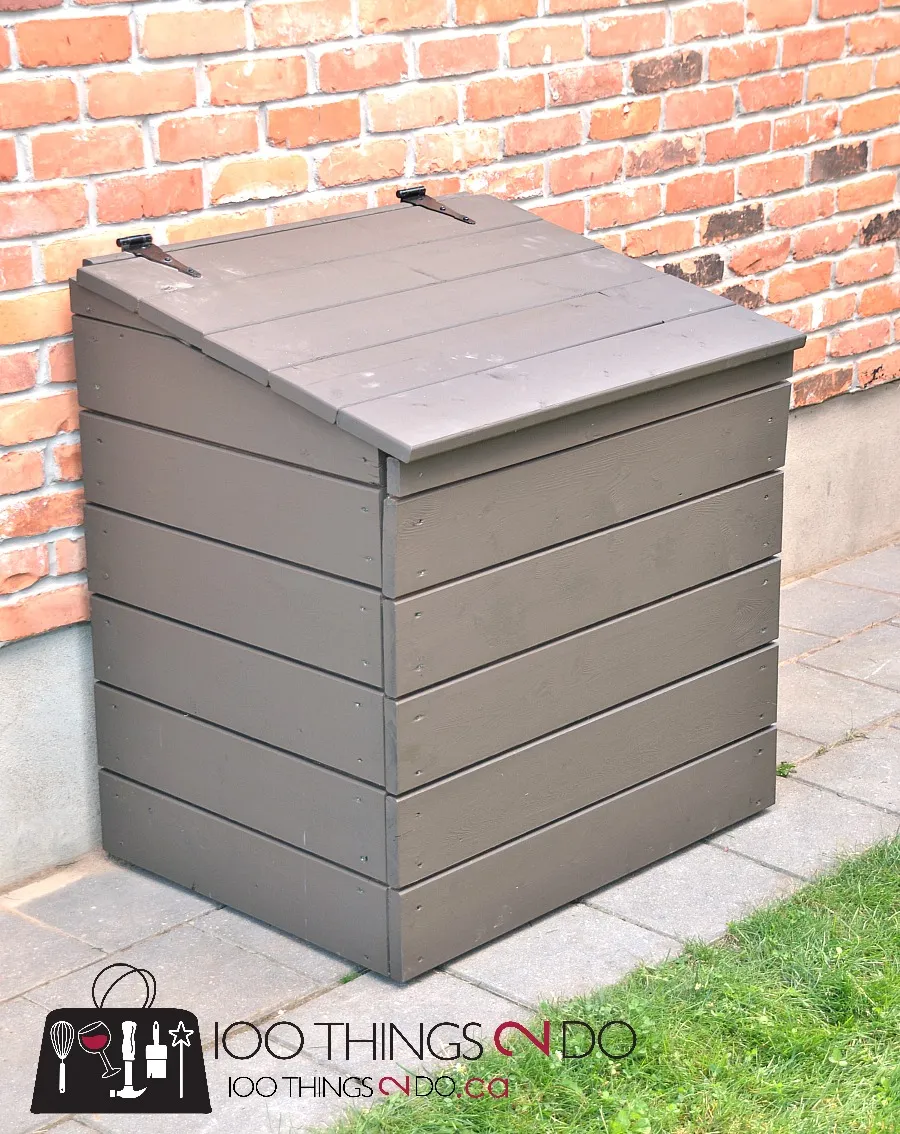Wood enclosure to hide garbage bags against a brick wall