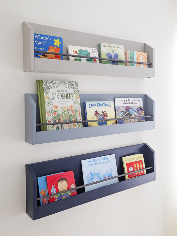 Three wall-mounted shelves filled with books