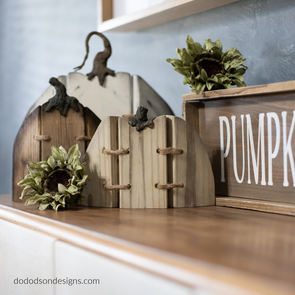 Wood board cut to look like pumpkins and laced together with twine