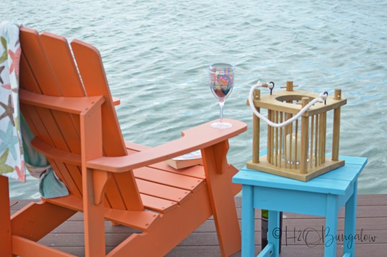 Wood lantern on a small blue table on a dock near water