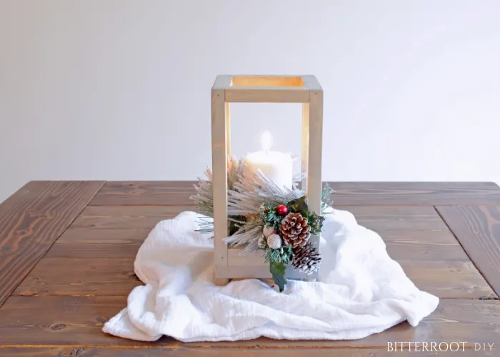 Wood lantern with Christmas greenery on a table