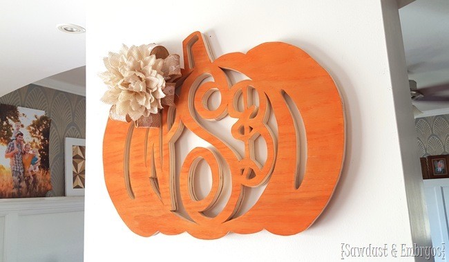 Pumpkin shaped piece of wood with a monogram cut out