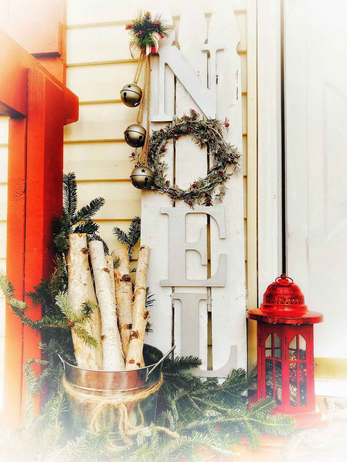 DIY wood Christmas sign that says NOEL on a porch