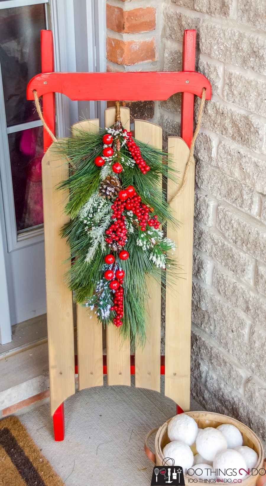 DIY wooden Christmas sled leaning near a front door