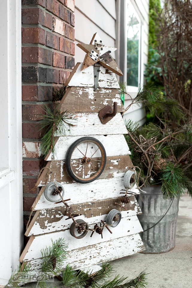 DIY outdoor Christmas tree made with recycled wood near a brick house