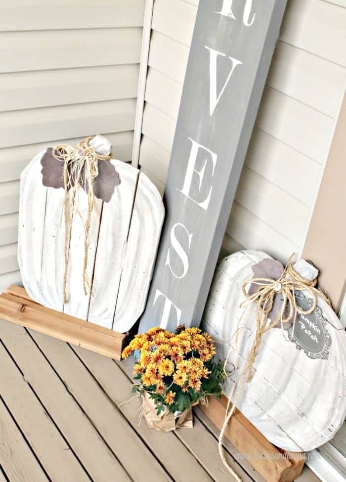 Whitewashed planks cut in the shape of a pumpkin with twine tied in a bow around the stem