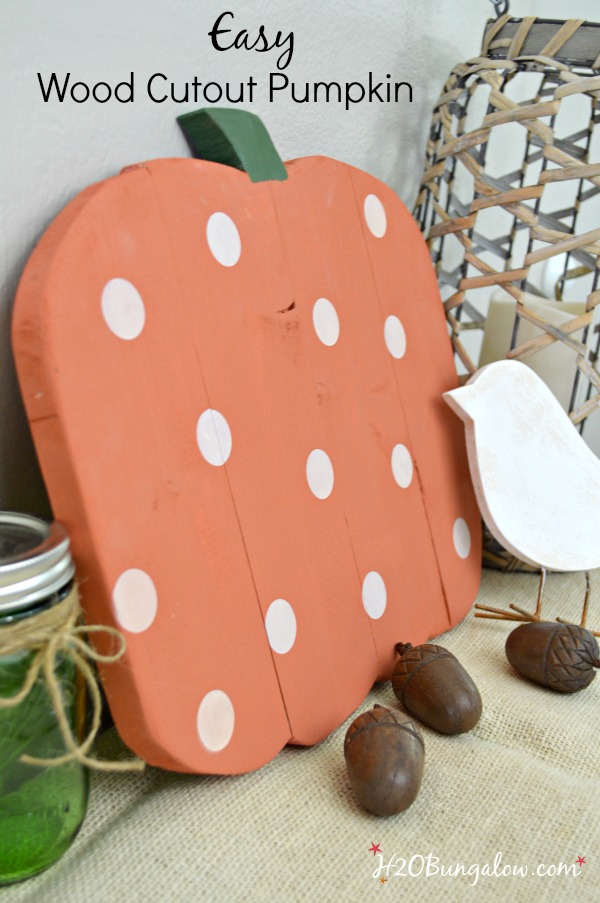 Several planks joined and cut in the shape of a pumpkin, painted orange with white polka dots