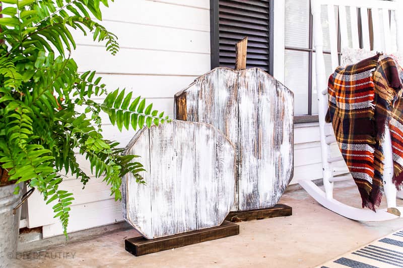 Planks stacked horizontally, cut in the shape of a pumpkin and whitewashed
