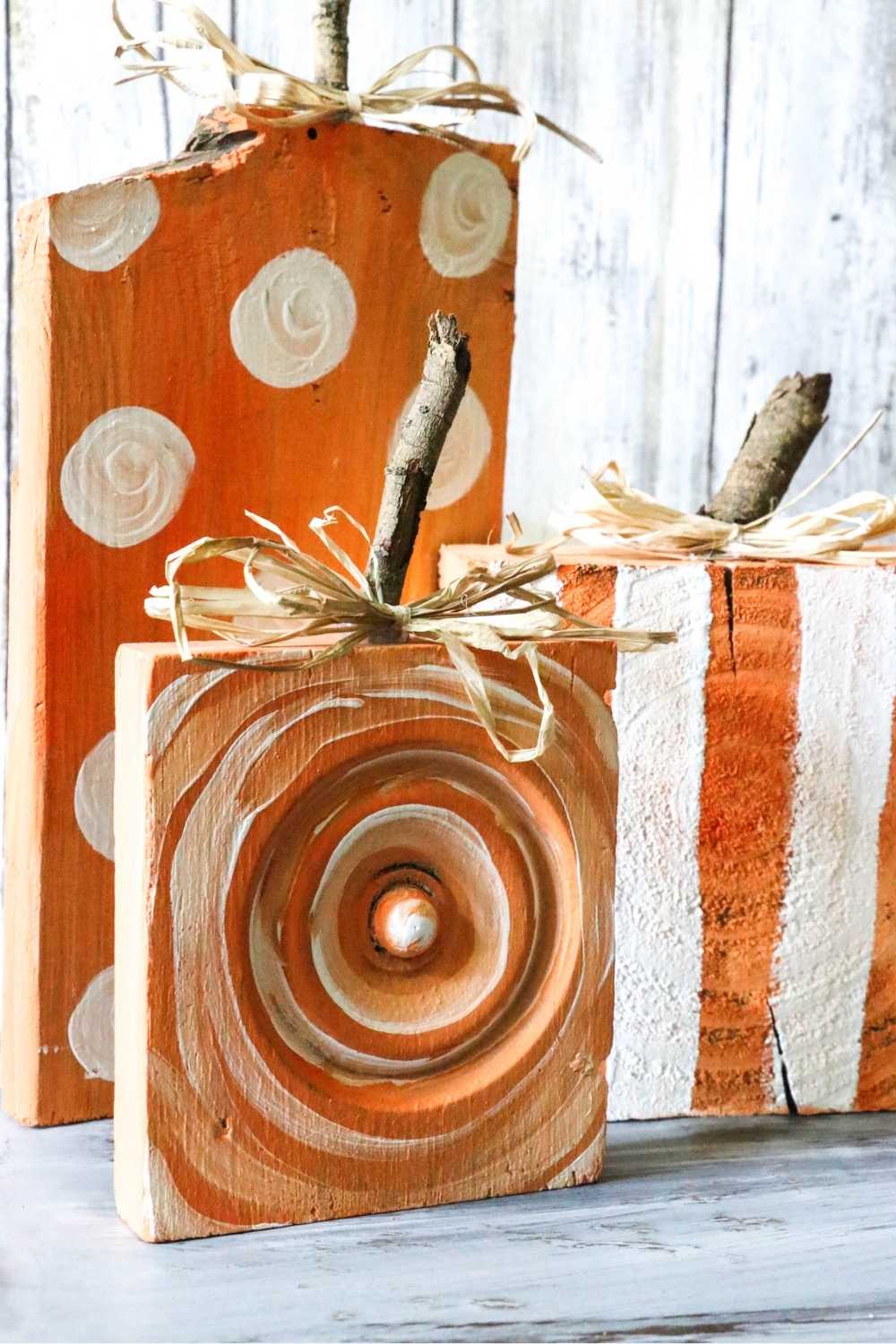Wood blocks painted in strips and polka dots to look like pumpkins