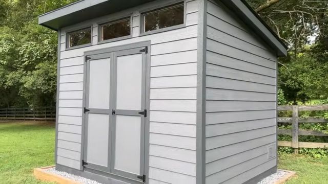 Large two-tone gray modern-style shed in a yard