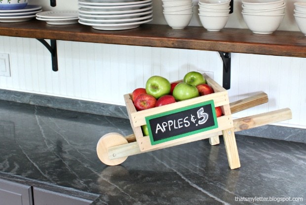 Tabletop wooden wheelbarrow filled with apples