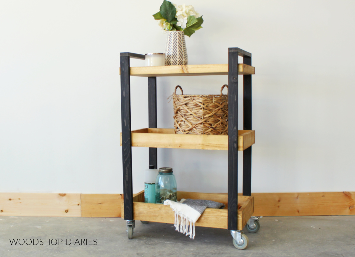 Rolling cart with a black painted frame and three natural colored shelves