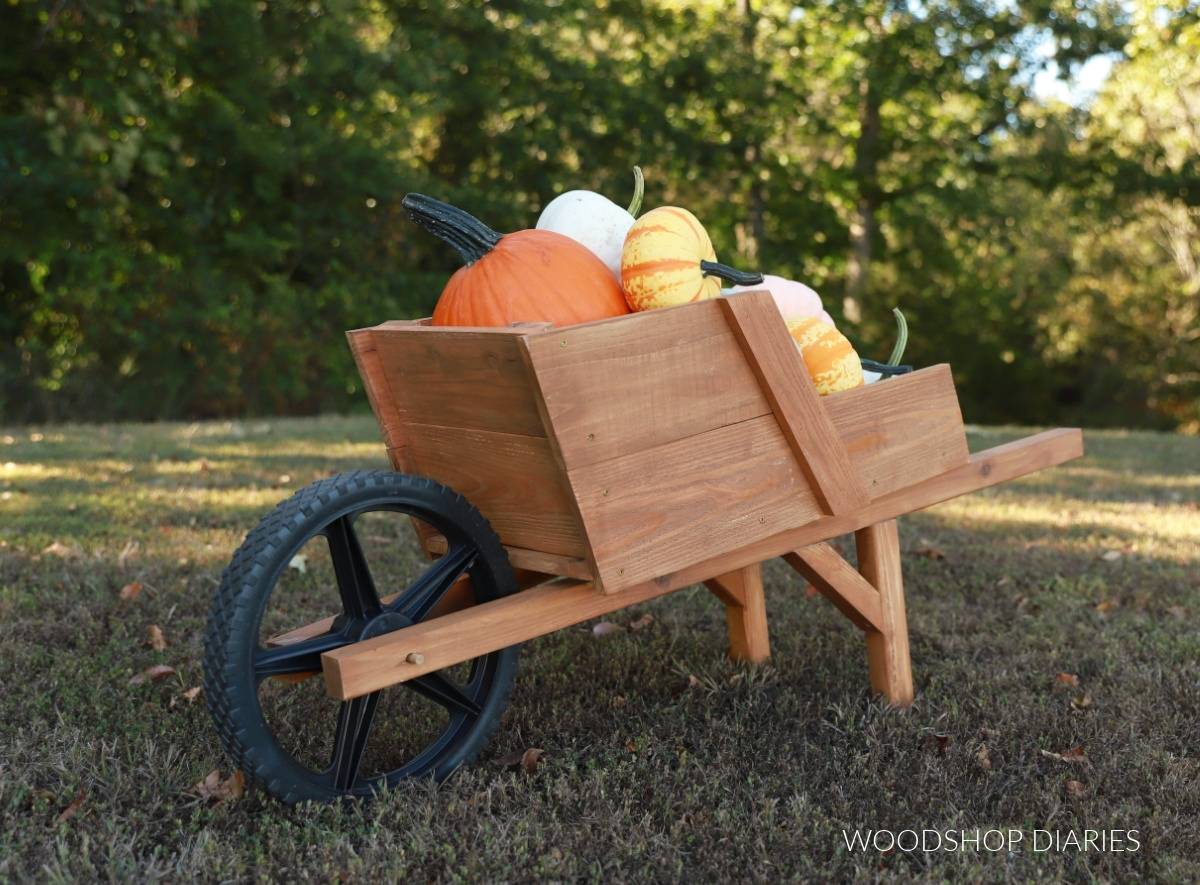 Stained wood wheelbarrow with a rubber tire filled with pumpkins and gourds