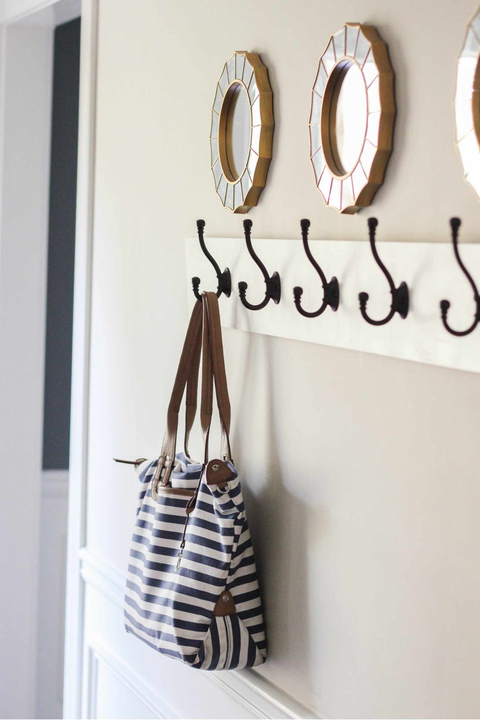 Board attached the wall with hooks and a purse hanging from one