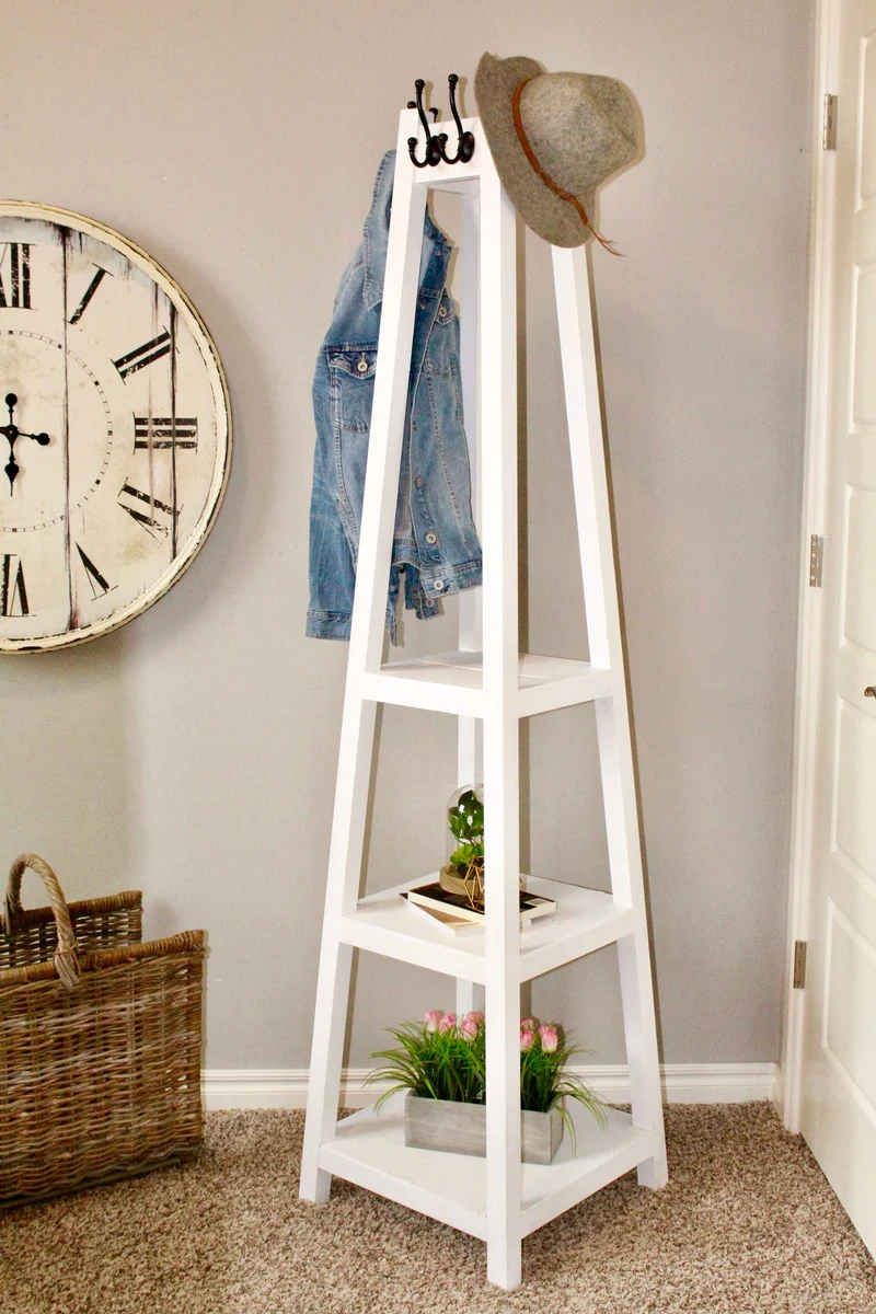 Splayed white painted coat rack with shelves below and hooks at the top
