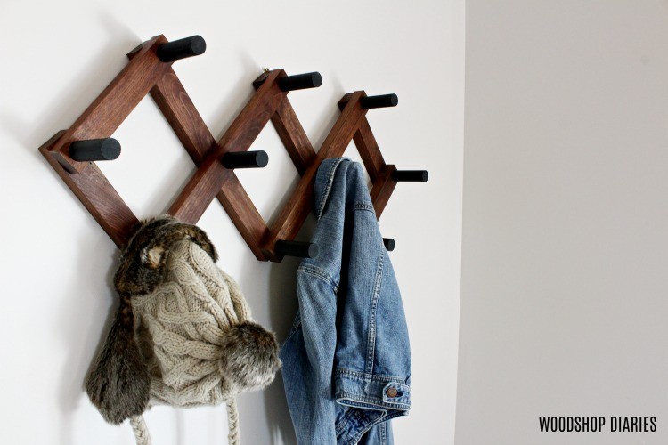 Accordion-style coat rack with pegs for hooks and hat and jacket hanging