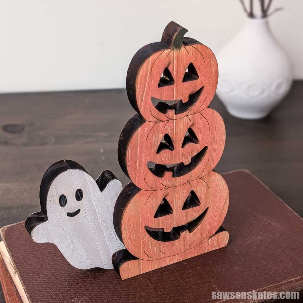 Looking down from above on wooden stacked jack-o-lanterns with a ghost sitting on books