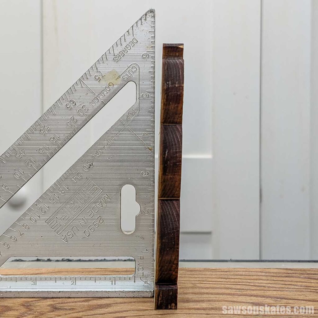 Speed square next to a piece of 1/2 wood cut with a laser cutter showing the angle