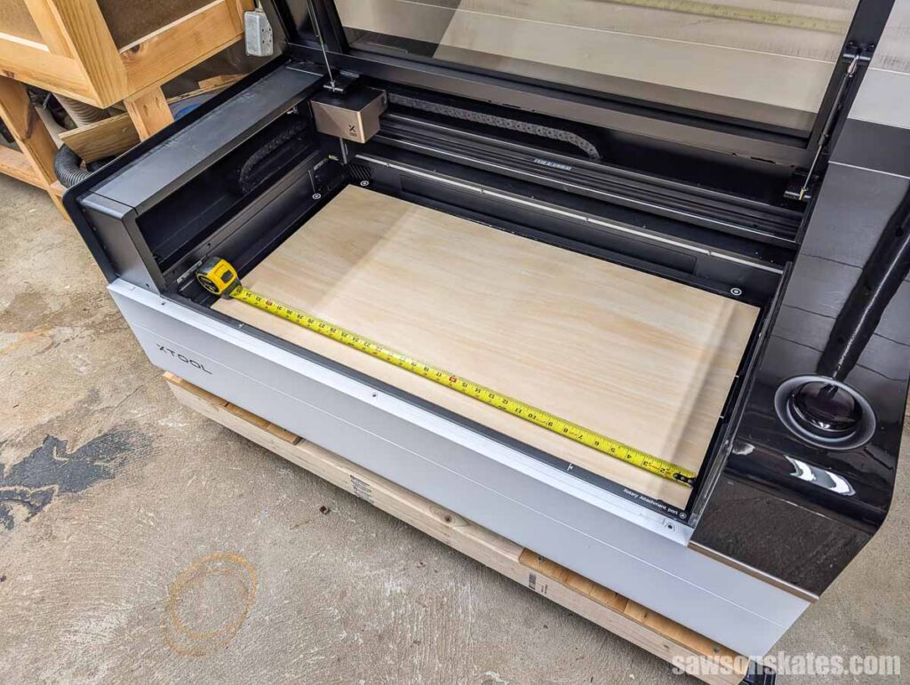Large piece of plywood inside an xTool P3 with a tape measure