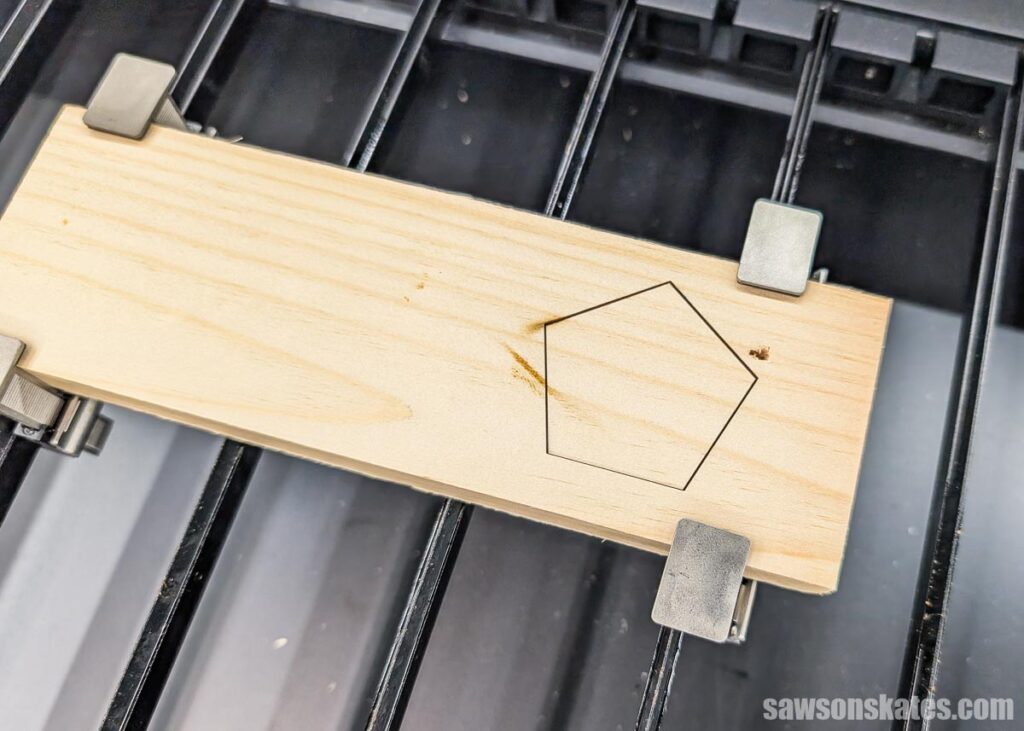 Pine board sitting inside a laser cutter