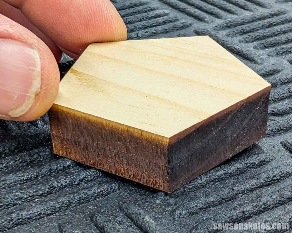 Fingers squeezing a 1/2" piece of pine cut with a laser cutter