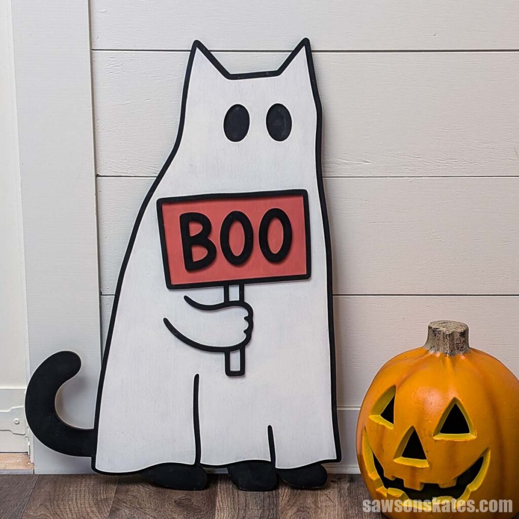 Wooden cat ghost holding a sign that says boo