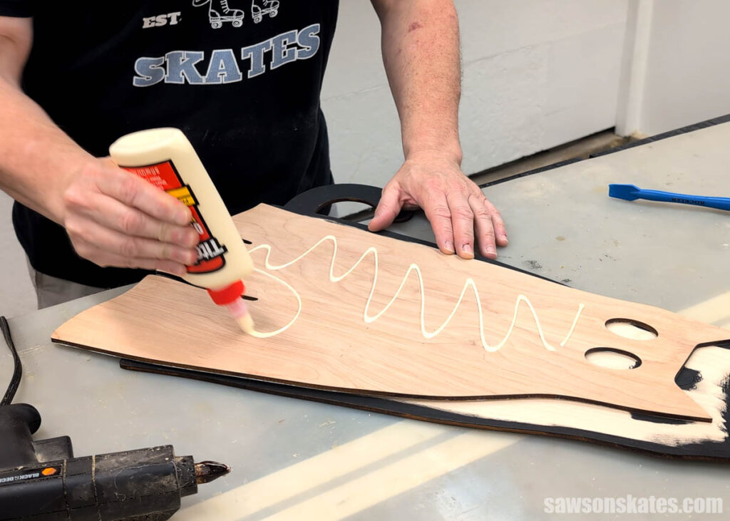 Scott applying glue to a wooden cat