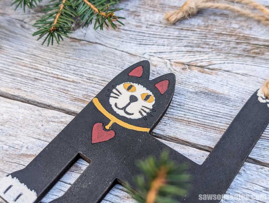 Close up of a folk art cat ornament's face.