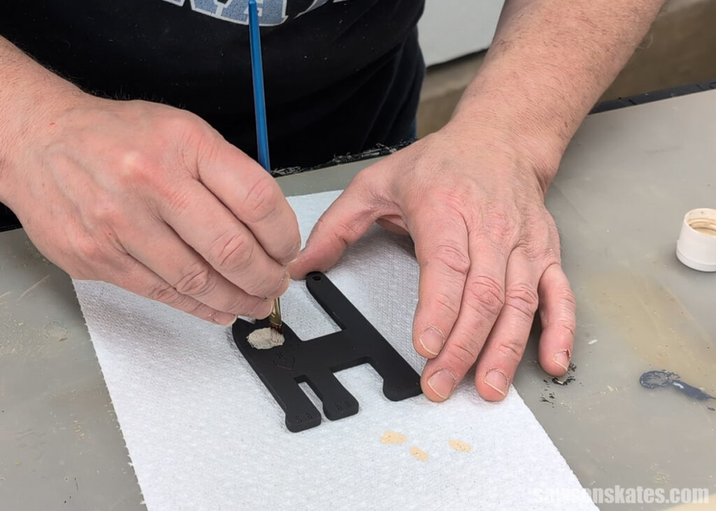 Scott painting a wooden cat ornament's face.