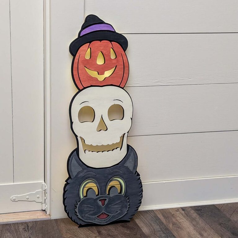 Halloween totem porch leaner with a jack-o-lantern, skull, and cat next to a doorway