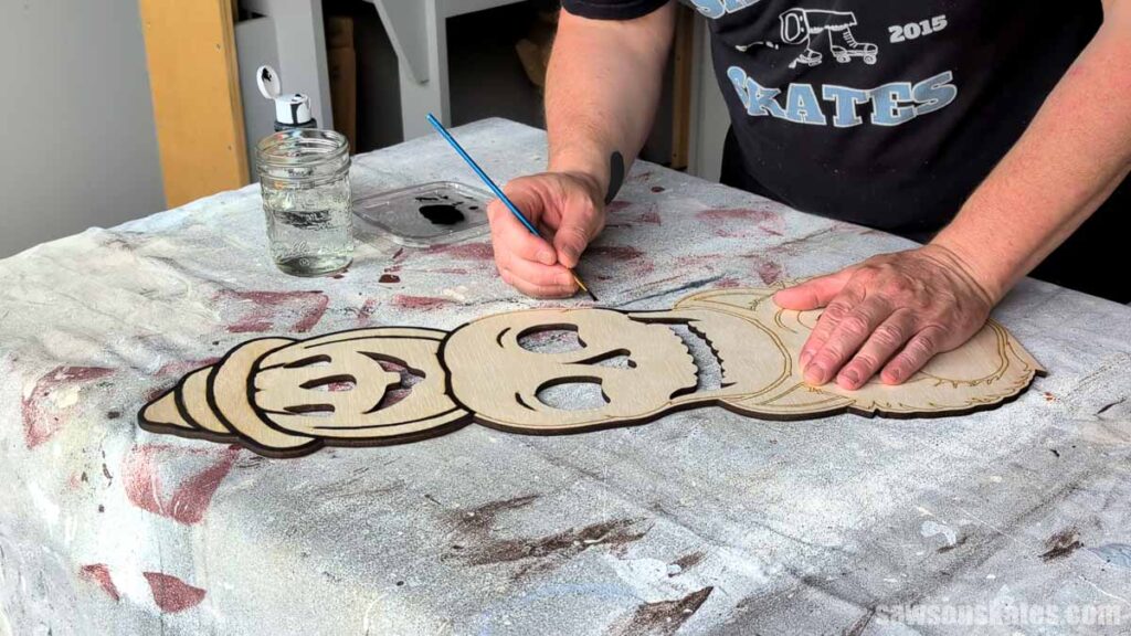 Scott painting the black outline around a Halloween totem