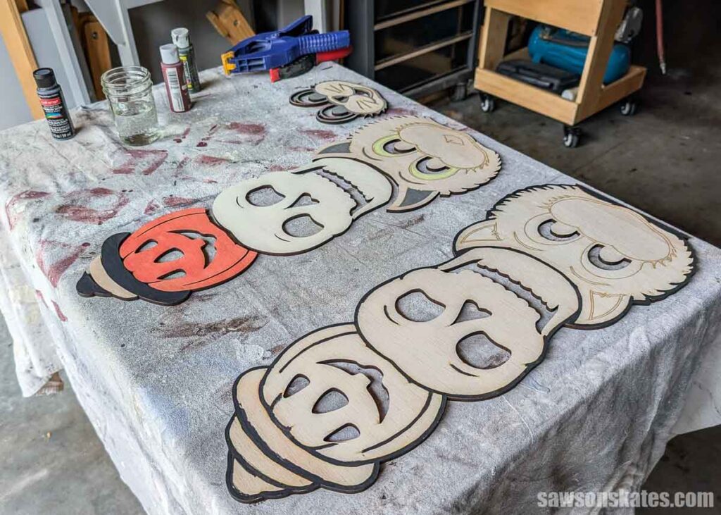 Progress shot of a Halloween totem laid out a on table with some parts painted