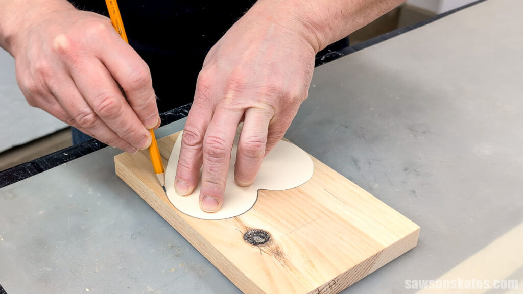 Tracing a heart shape onto a board with a pencil