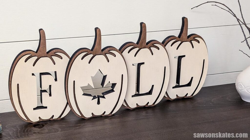 Pumpkin-shaped layered fall sign on a table